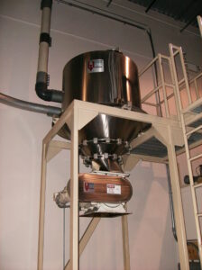 A negative pneumatic receiver featuring extensive pipes and machinery for material transport.