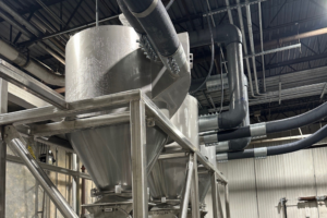 A large industrial pneumatic conveying system featuring extensive pipes and machinery for material transport.