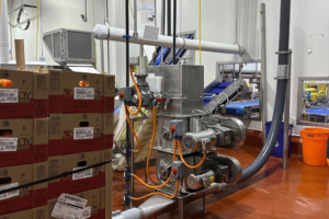 A detailed diagram of pneumatic transfer systems moving food products through stainless steel pipes in a processing facility.